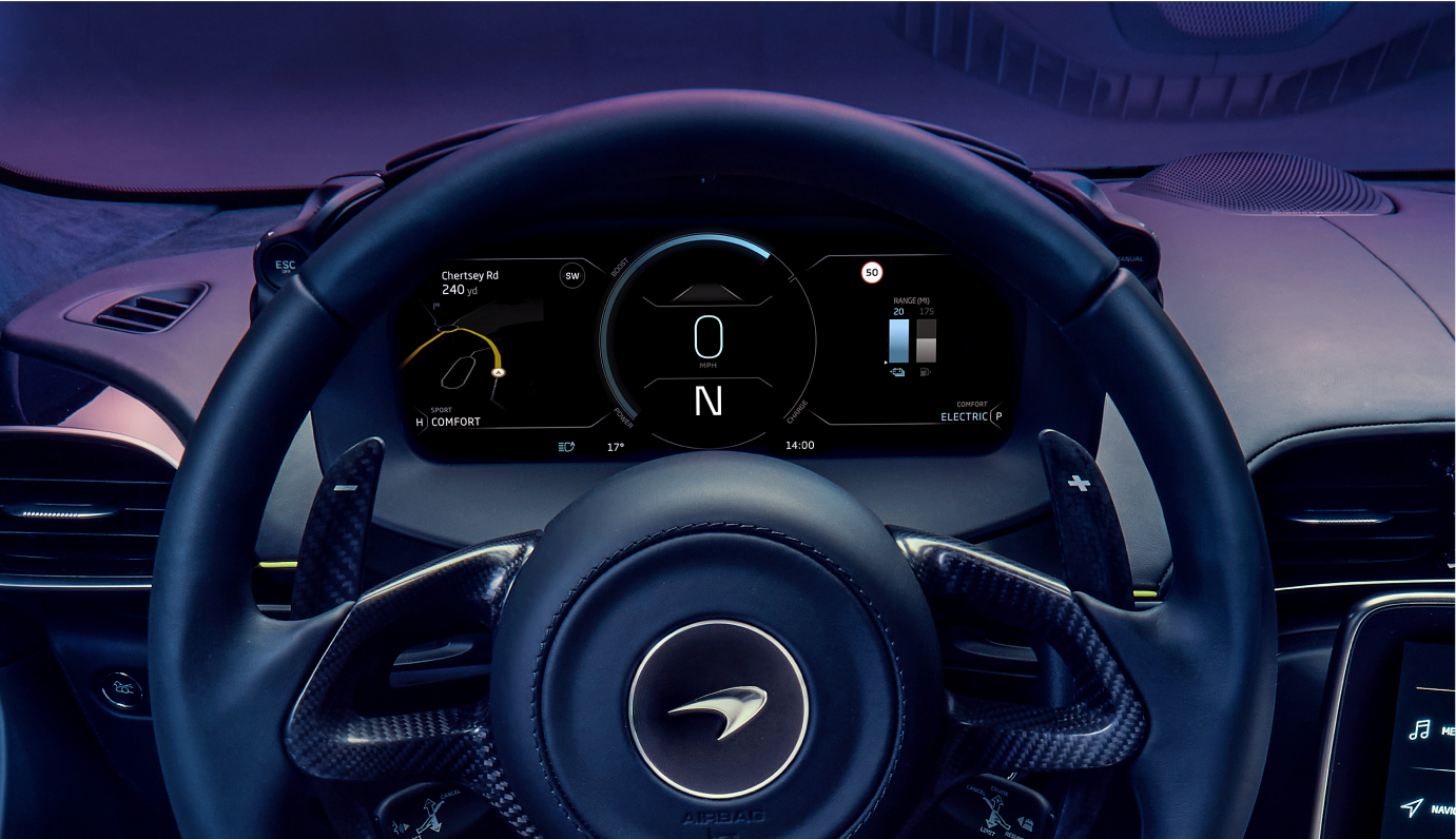 A close-up of the digital dashboard and steering wheel of a McLaren Artura, showing the speedometer, navigation, and 'Electric' driving mode.
