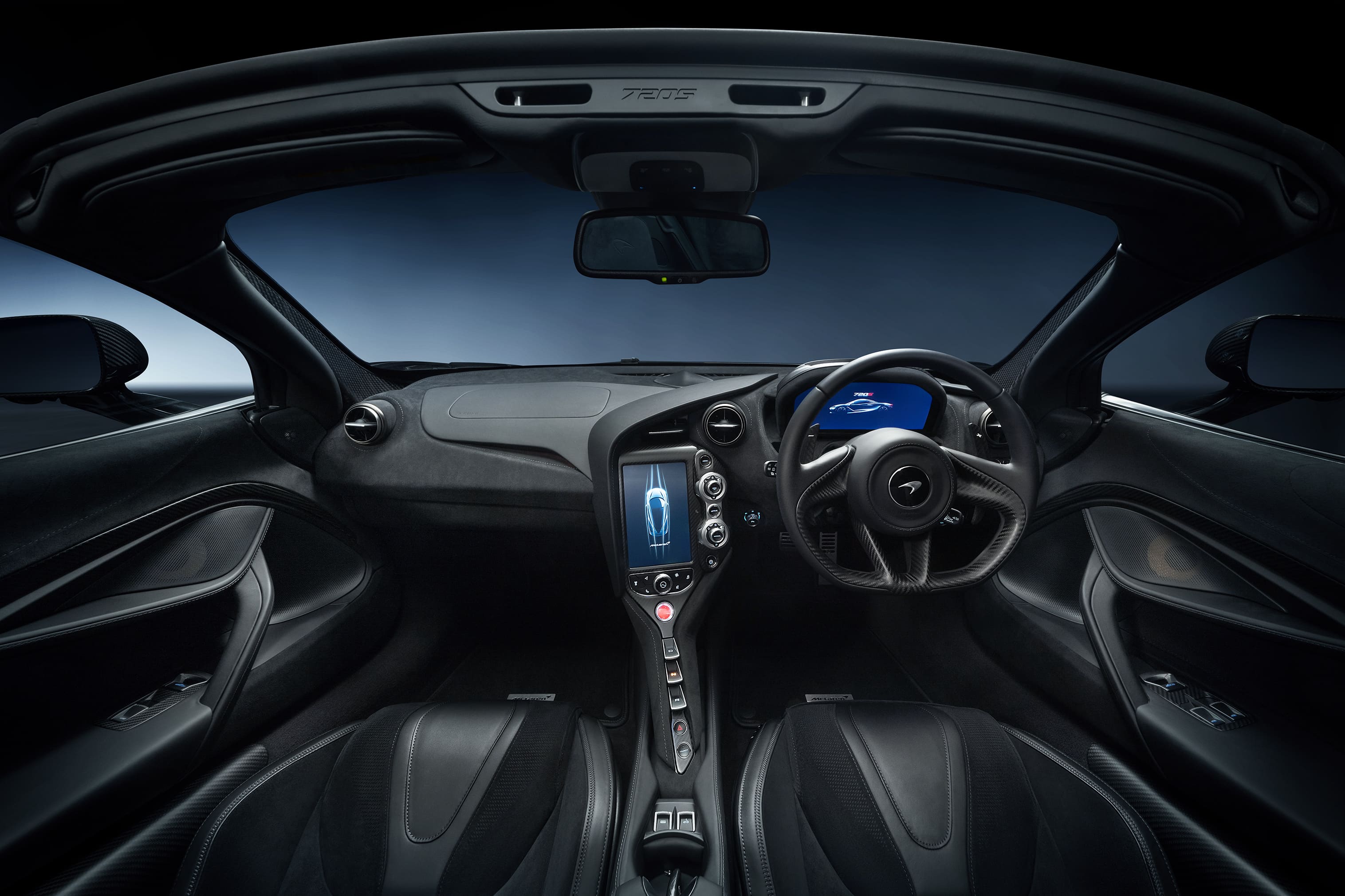 A close-up shot of a black McLaren 720S Spider, showcasing its open dihedral door and a detailed view of the alloy wheel and brake system.