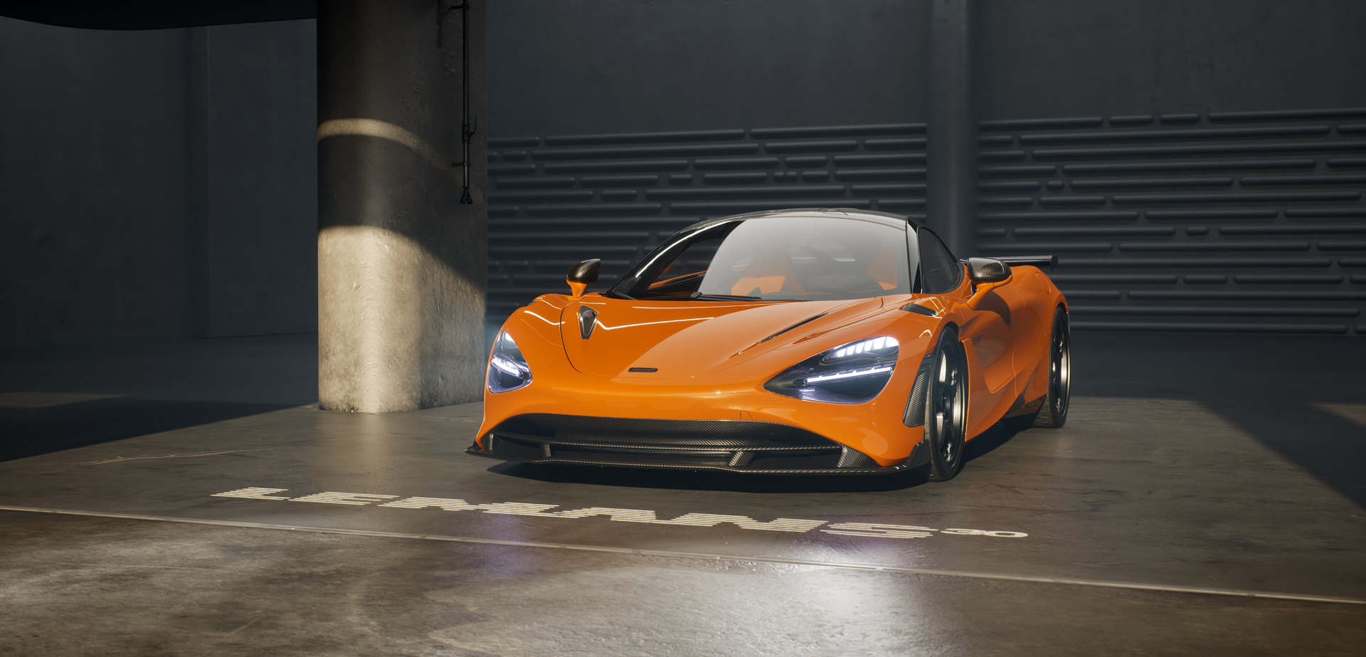 A vibrant orange McLaren 750S Le Mans edition is parked in a garage with the 'Le Mans 30' anniversary logo projected onto the floor in front of it.