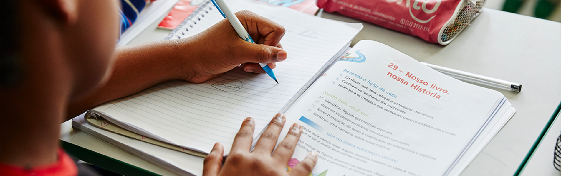 A child working in a school workbook.