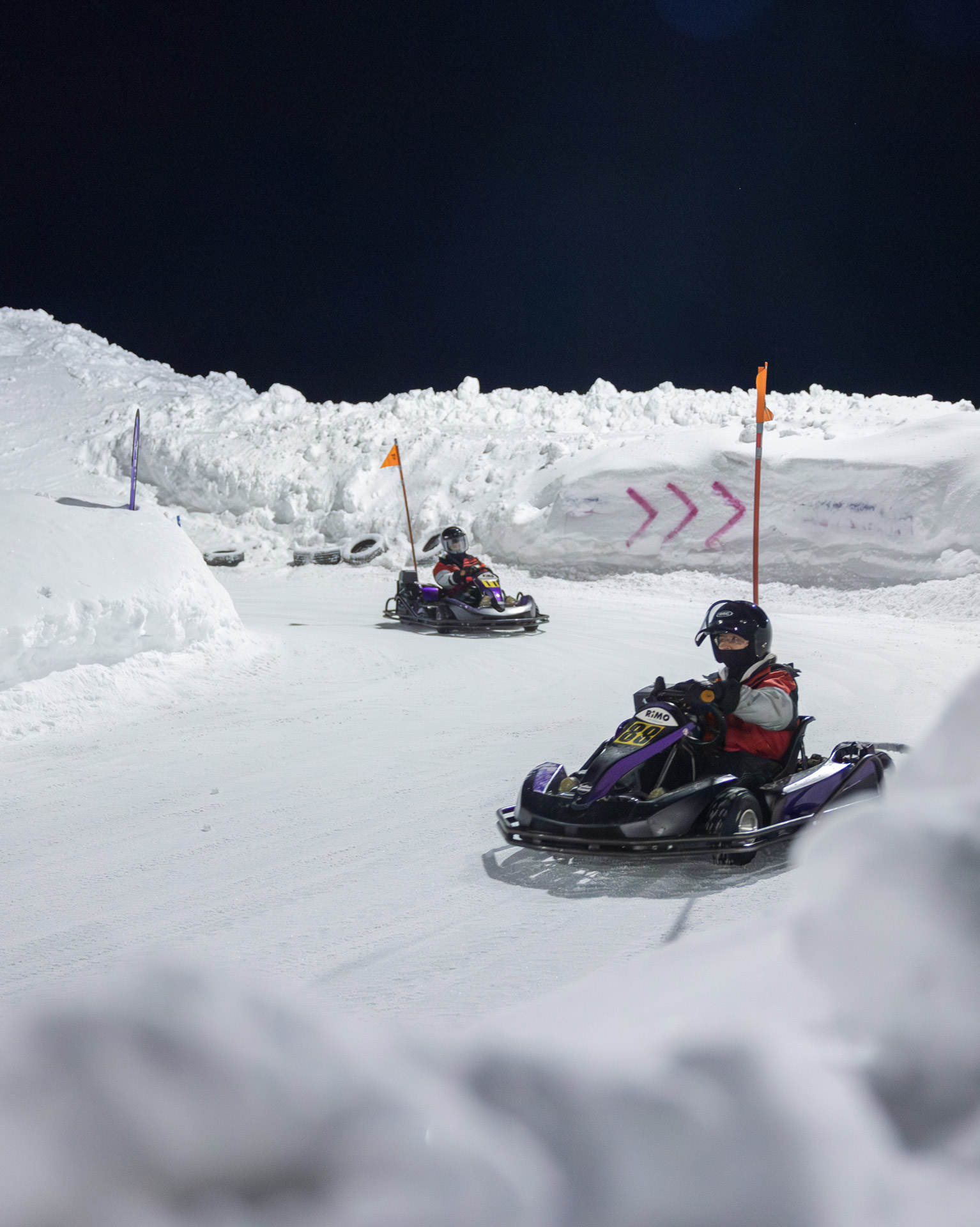 Guests at a McLaren Arctic Experience event go-karting on a snow and ice course.