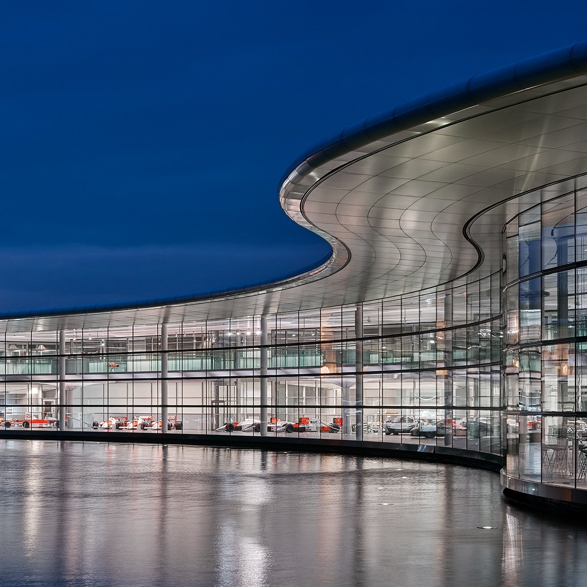 McLaren Technology Centre lit up at night, on the waterfront.