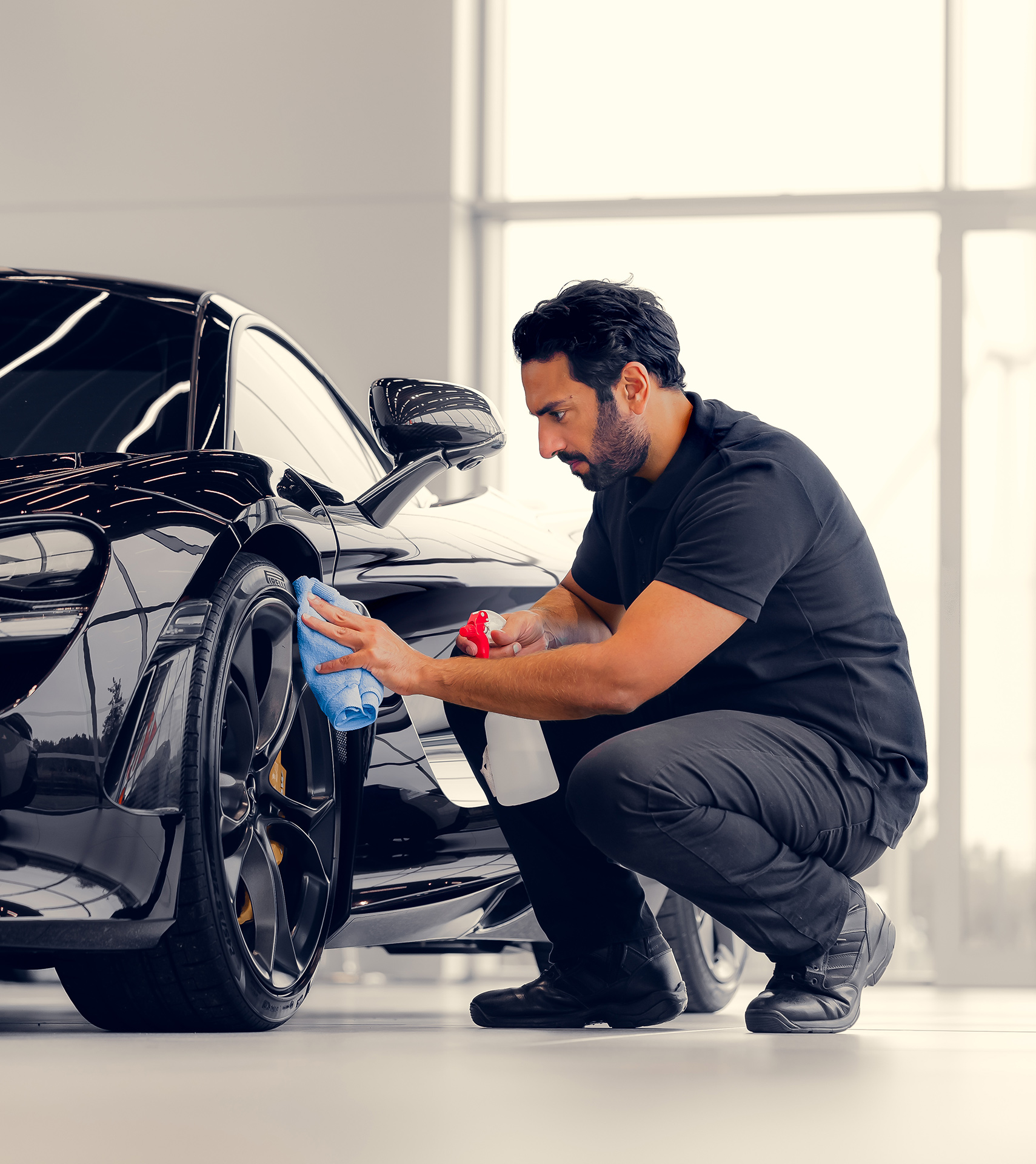 A McLaren specialist carefully detailing a pre-owned car to prepare it for a new owner.