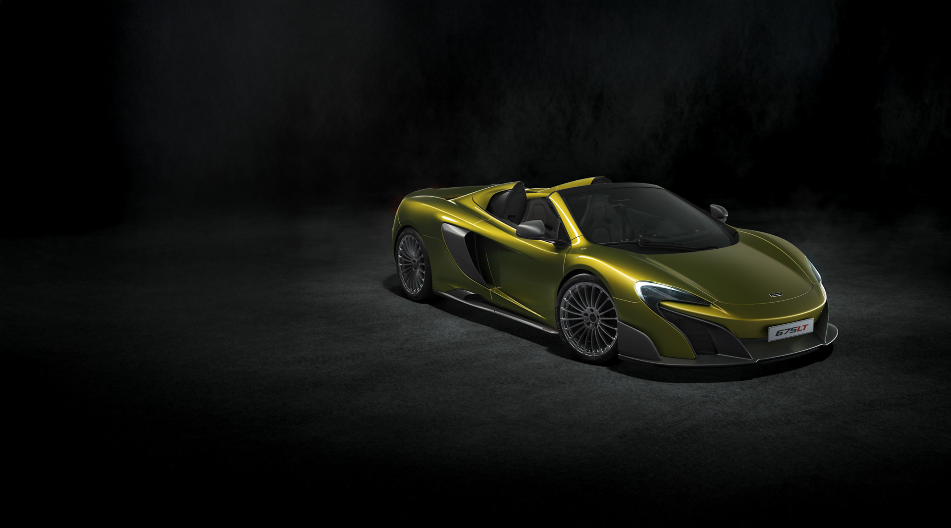 Olive green McLaren 675LT Spider, photographed in a dark environment.