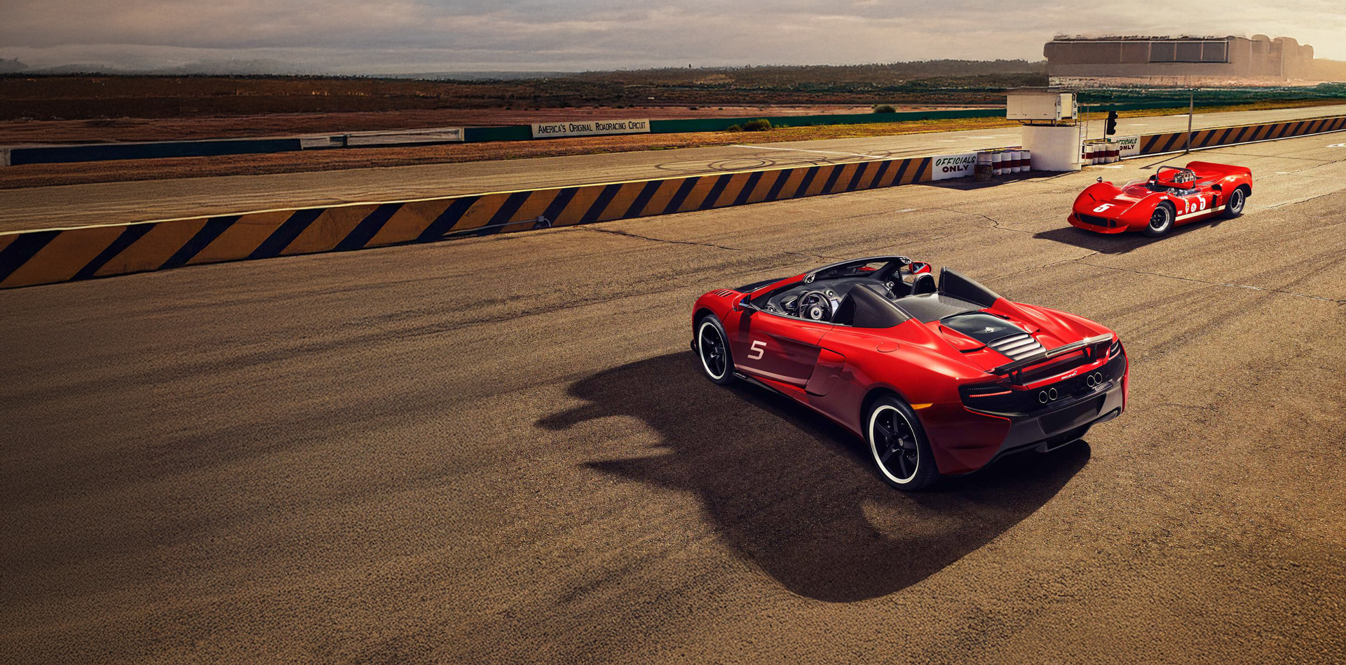 The red McLaren 650S CAN-AM Spider parked perpendicular to an old red CAN-AM race car on a race track, both with the number 5 on their body.