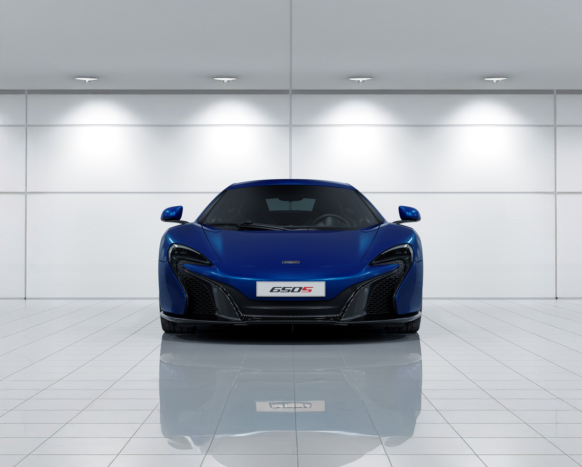 Front view of a blue McLaren 650S in a clean, bright environment.