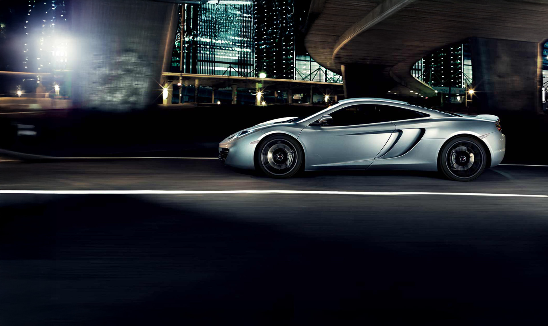 White McLaren 12C parked outside of a modern, white building.