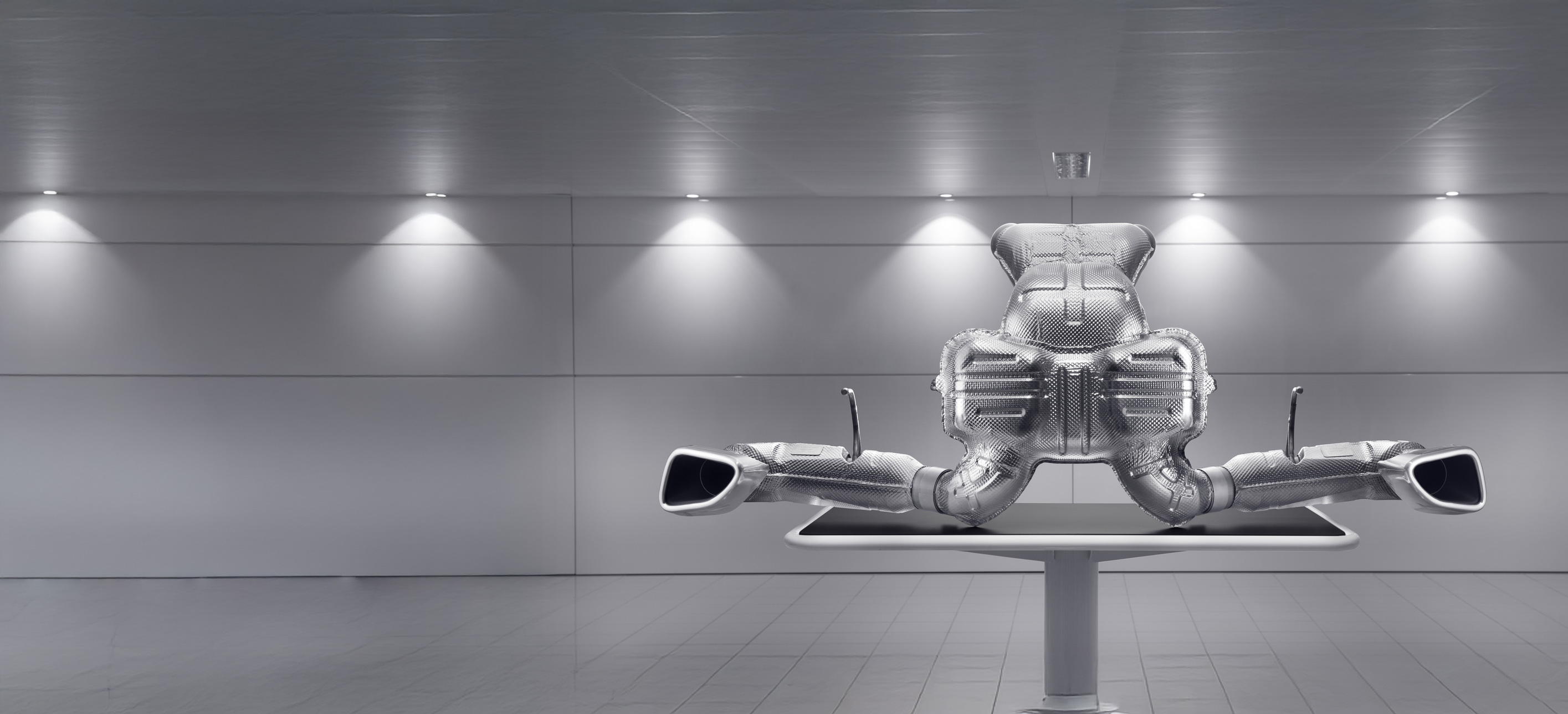 A large, detailed image of a McLaren exhaust system and muffler, on display in a clean, modern setting.