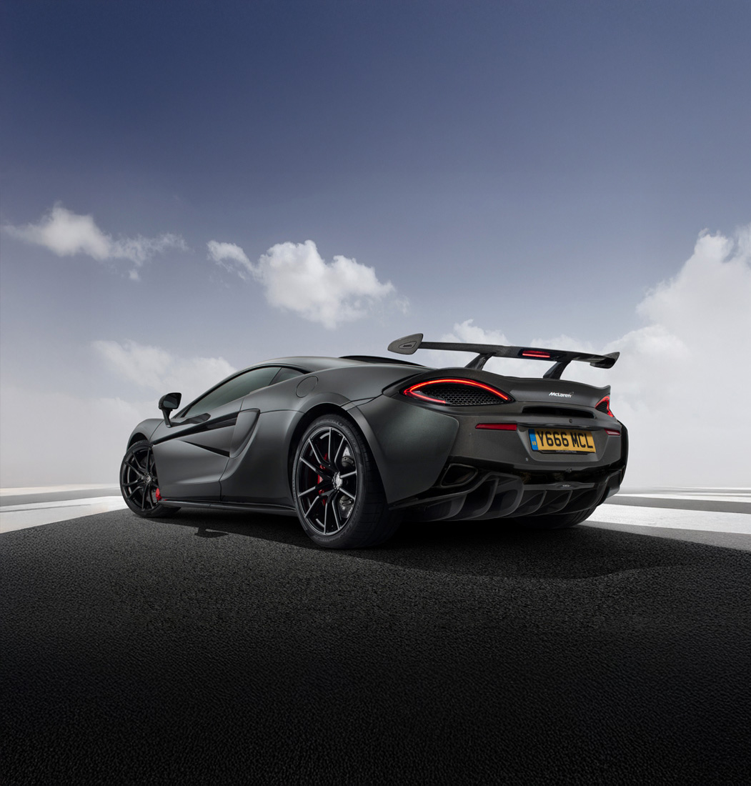 McLaren 600LT in matte grey, emphasizing the curved taillight design and the aggressive rear wing against a cloudy sky.