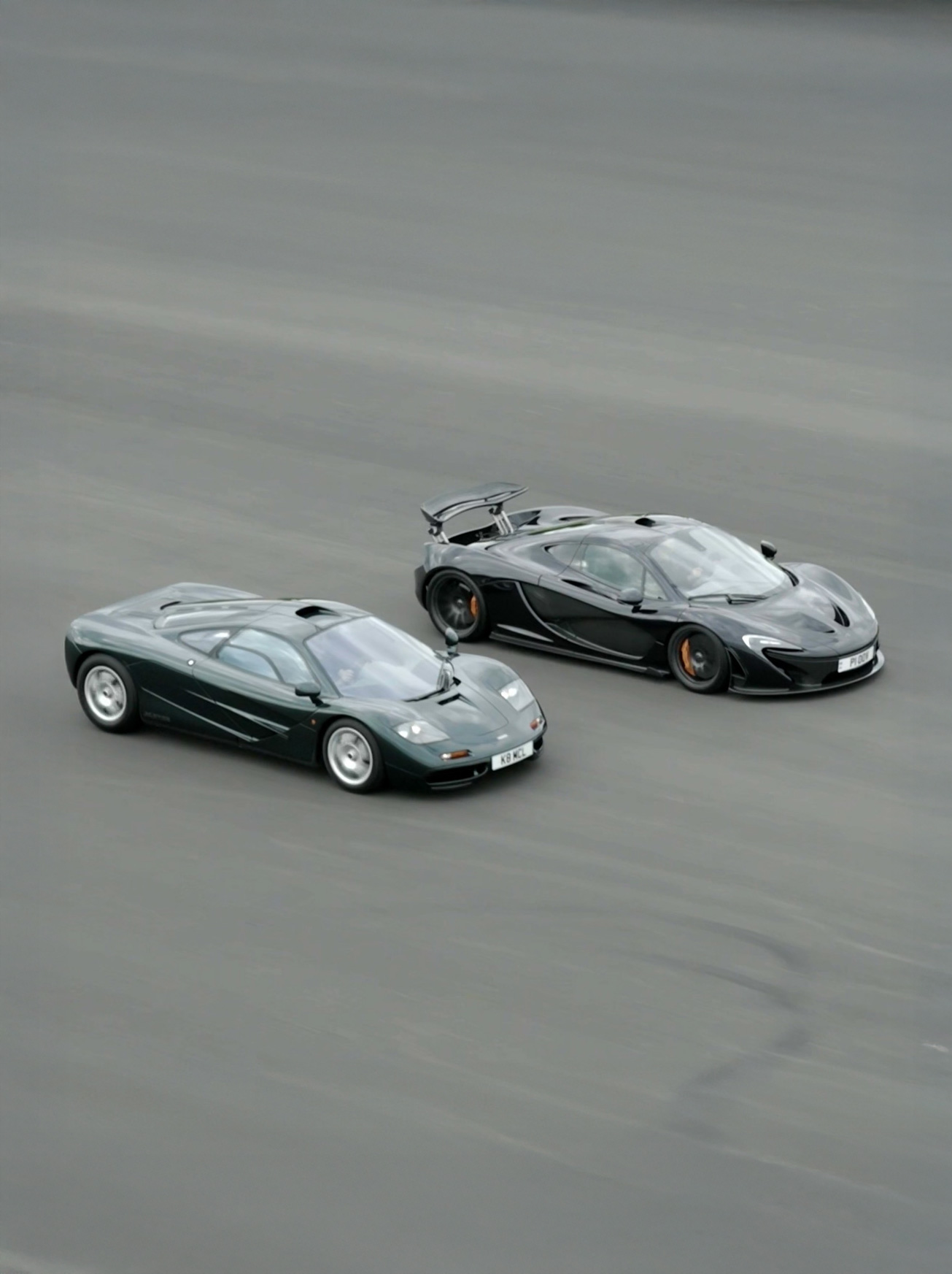 A McLaren F1 and a McLaren P1 driving side by side, on track.