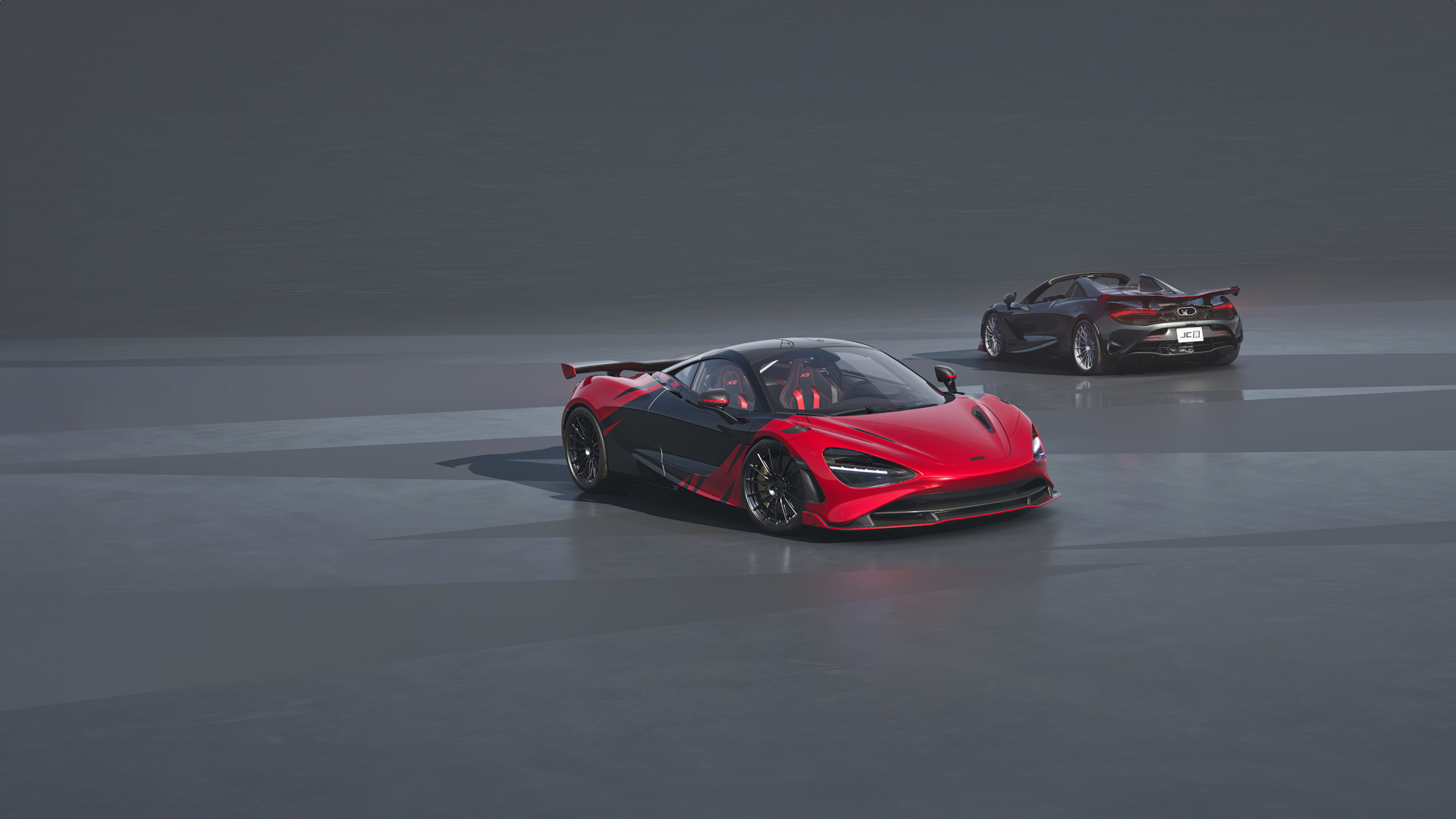 Two McLaren 750S JC96 special edition supercars, a red and black coupe and a dark grey spider, side-by-side.