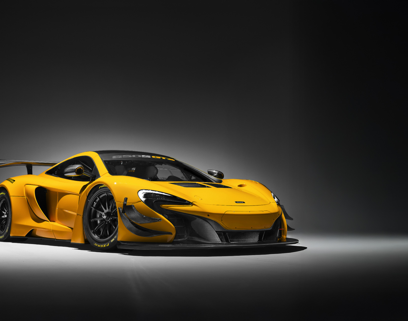 Bright yellow McLaren 650s GT3 on a grey background.
