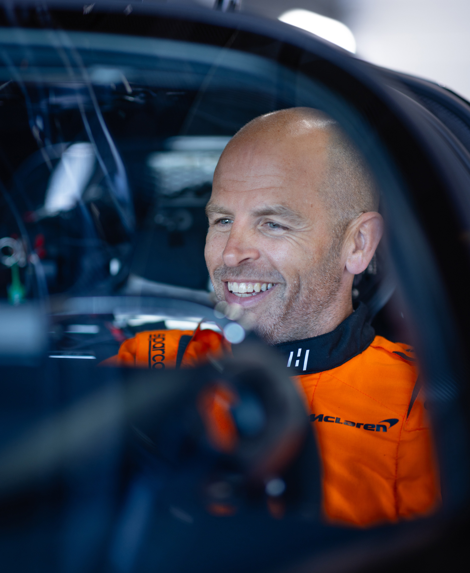McLaren test driver Gareth Howell sat in the drivers seat of the McLaren W1 whilst smiling and preparing for the test drive.