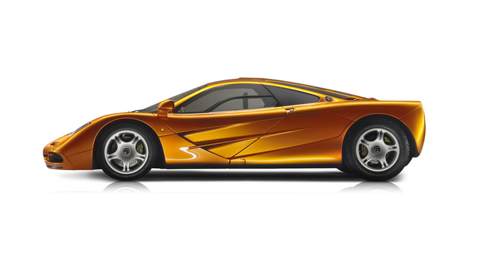 Side view of a metallic orange McLaren F1, shown on a white background.