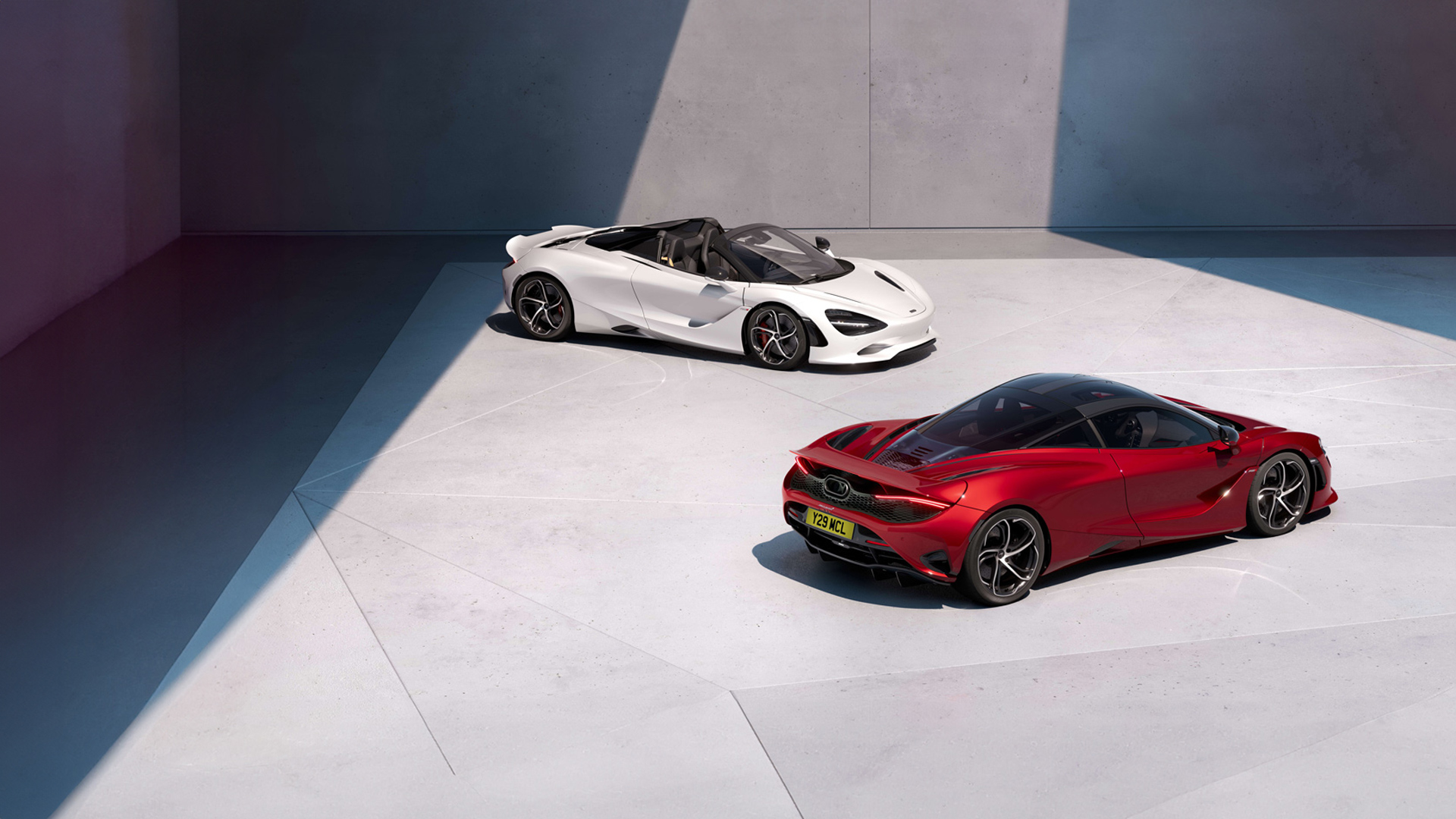 McLaren 750S Coupe in Red (foreground) and 750S Spider in White (background) showcased in a minimalist luxury showroom.