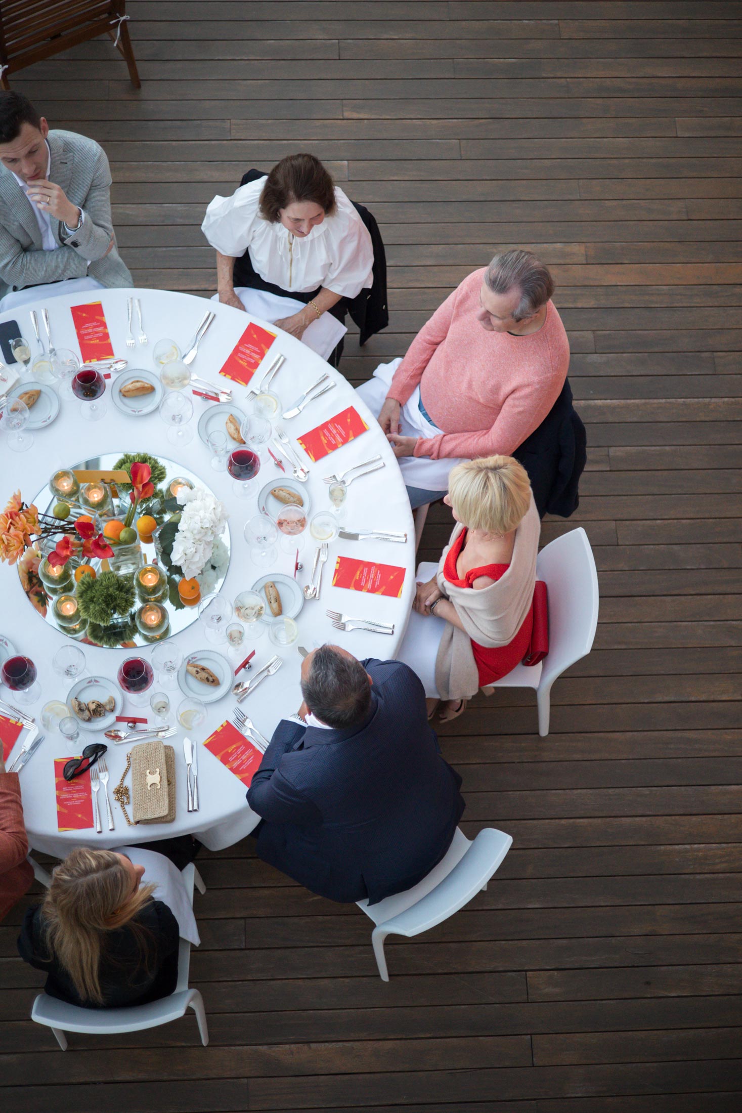 Overhead view of guests seated at a beautifully set round table, showcasing the premium dining and hospitality package offered by McLaren during the F1 race.