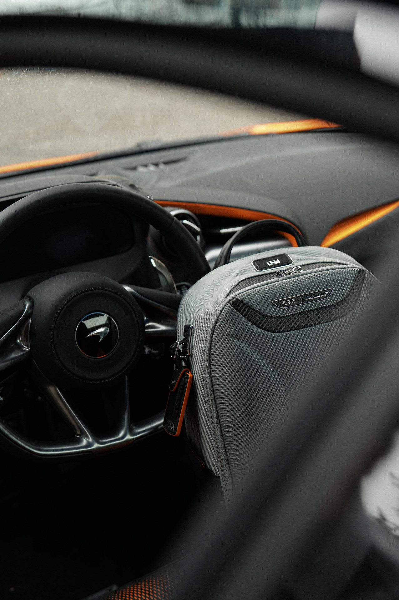 McLaren TUMI backpack sat in the drivers seat of a McLaren.