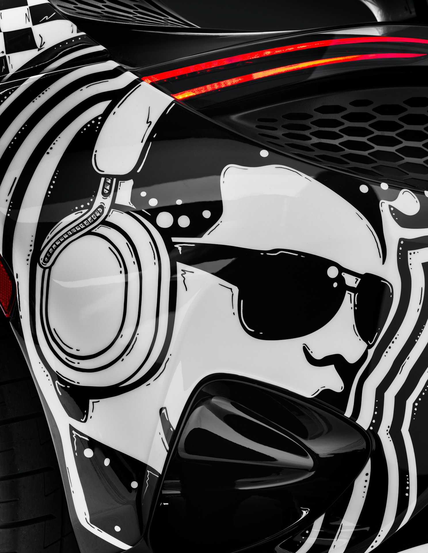 Close-up of a hand-painted graphic on the MSO Project Viva rear fender depicting a stylized cartoon character wearing sunglasses and headphones, reflecting the Las Vegas music and nightlife theme.