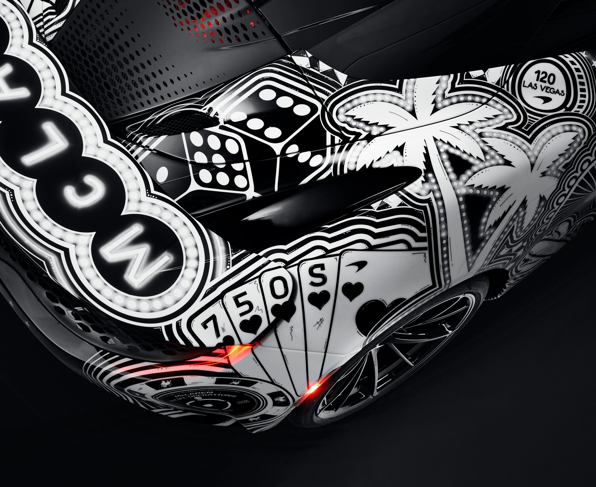 Close-up of the rear bodywork of the MSO Project Viva showing detailed, hand-painted Las Vegas motifs including casino dice, a palm tree, and playing cards with a 750S emblem, blending art with McLaren performance.