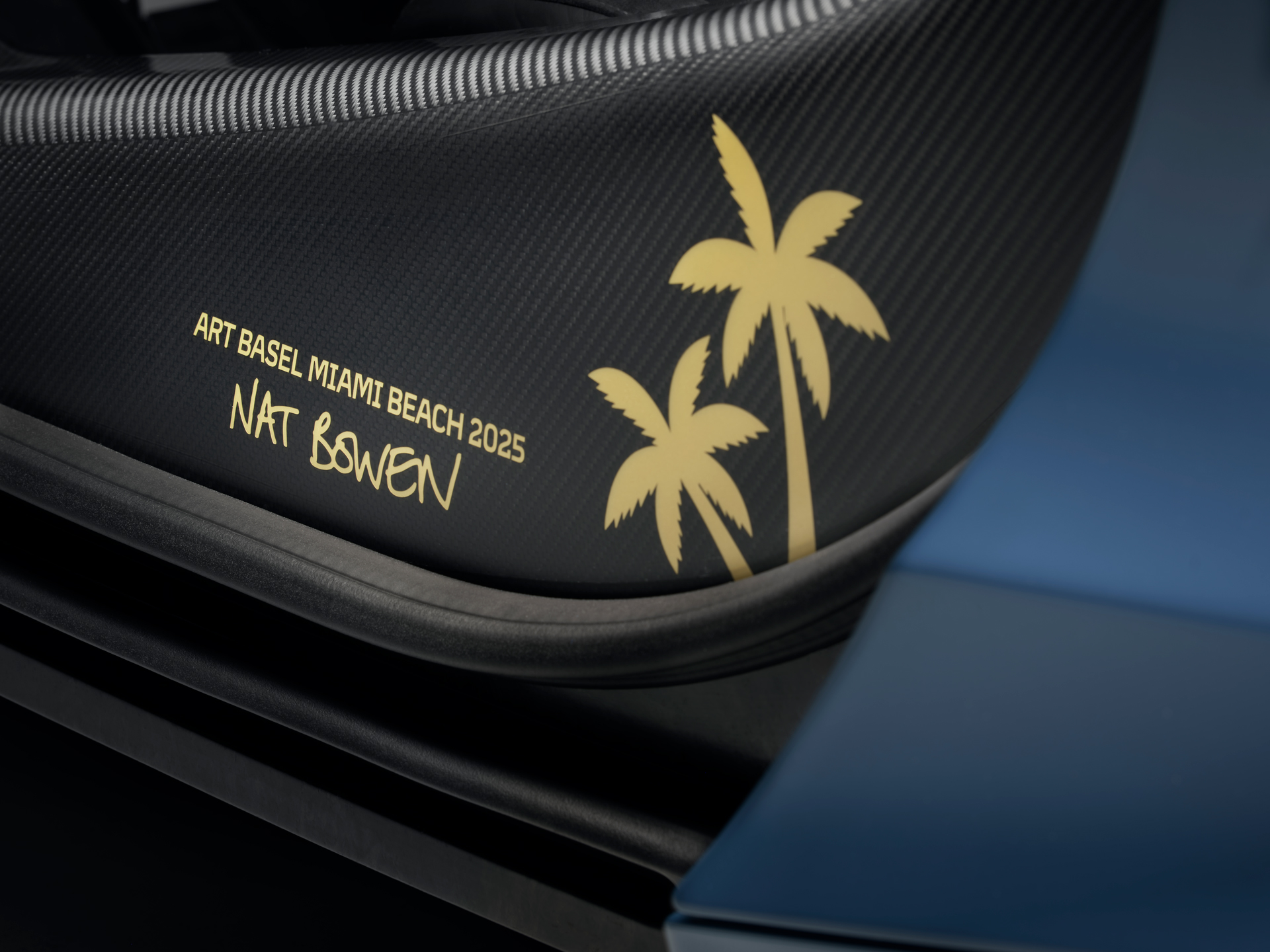 A gold sticker on the microfiber interior of the Project Chromology 750s by MSO and Nat Bowen. The sticker shows two palm trees next to text which reads 'ART BASEL MIAMI BEACH 2025, NAT BOWEN'.