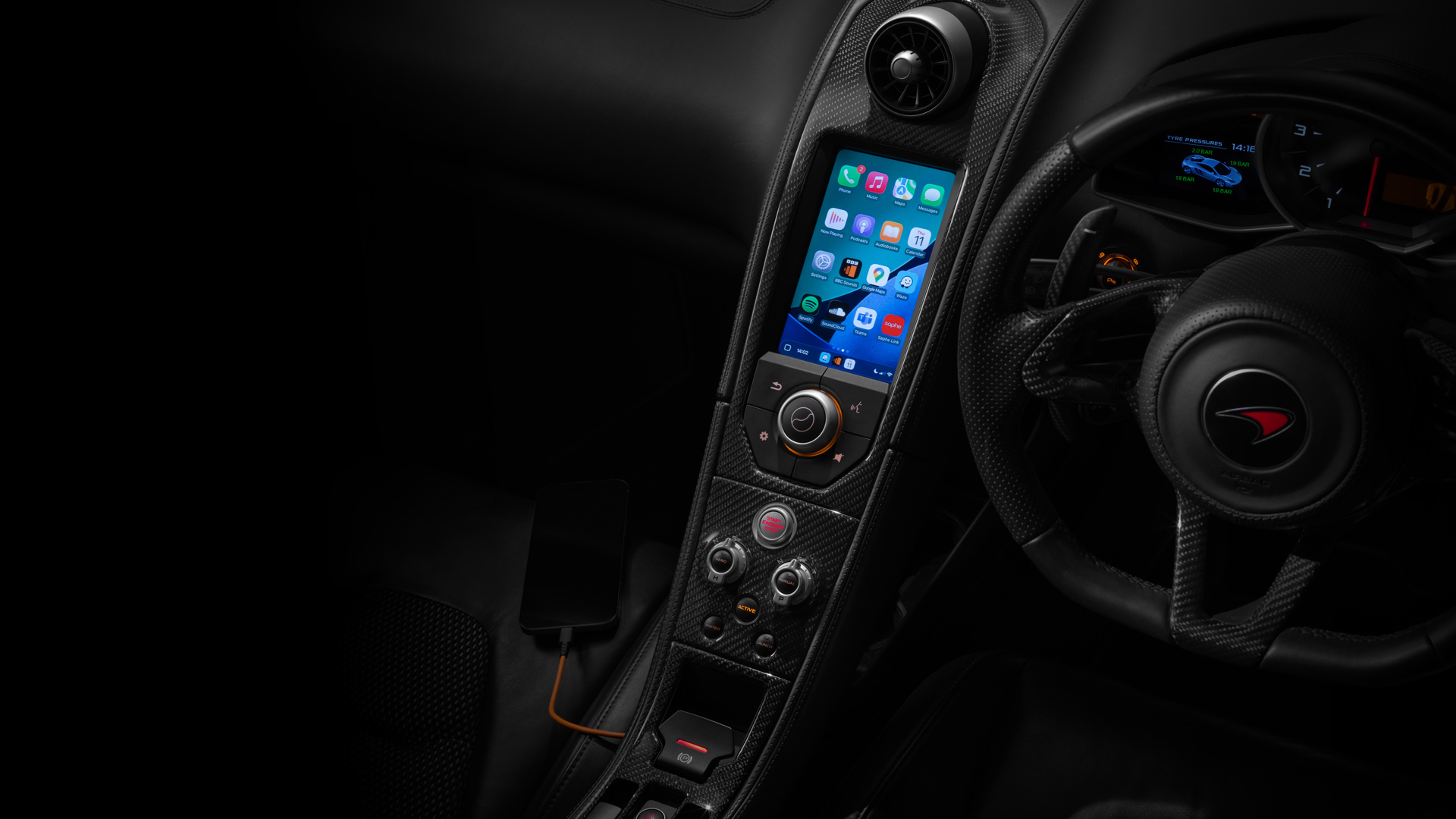 Central console of a McLaren supercar displaying the apple carplay interface.