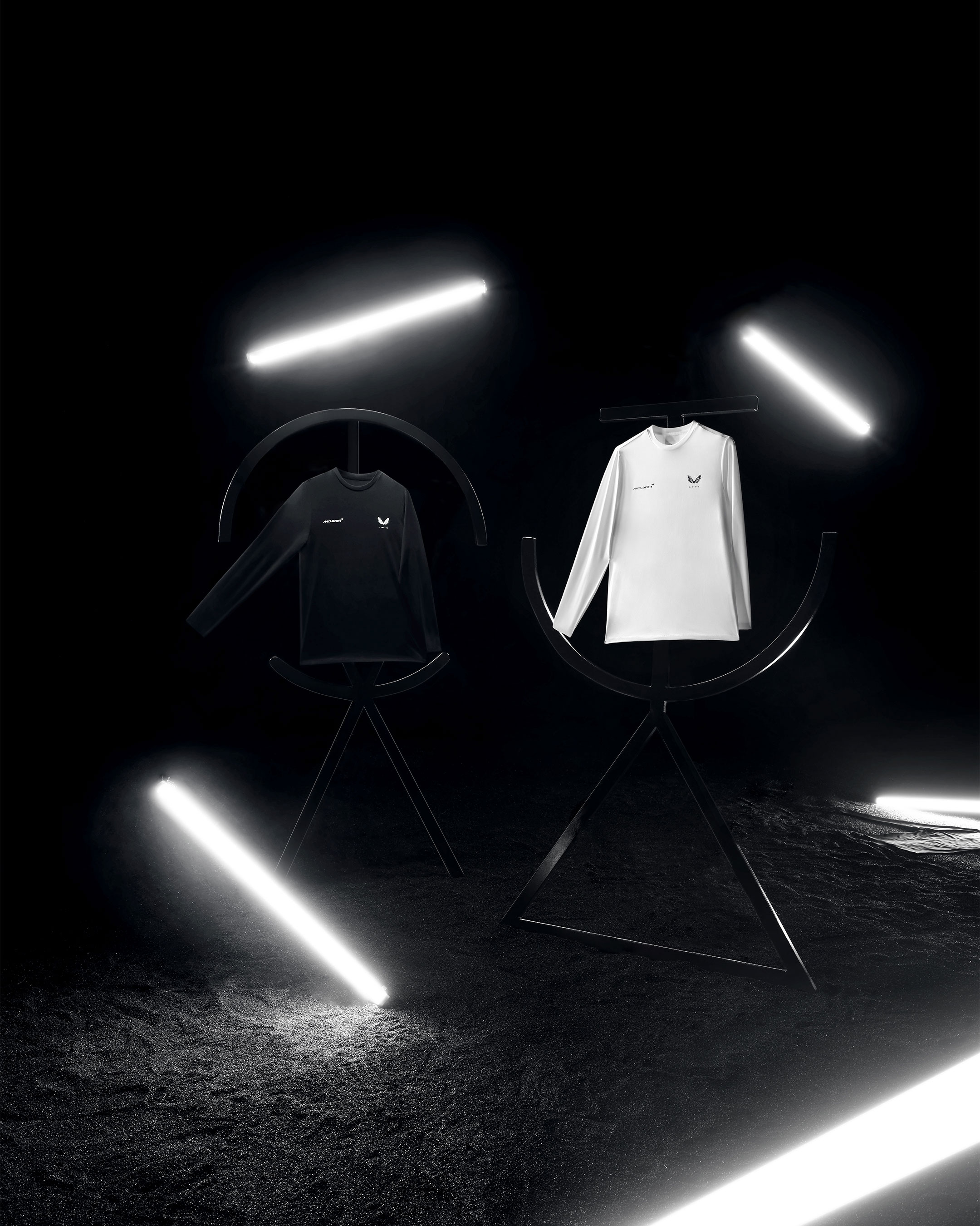Black and white McLaren Castore long-sleeve shirts on display.