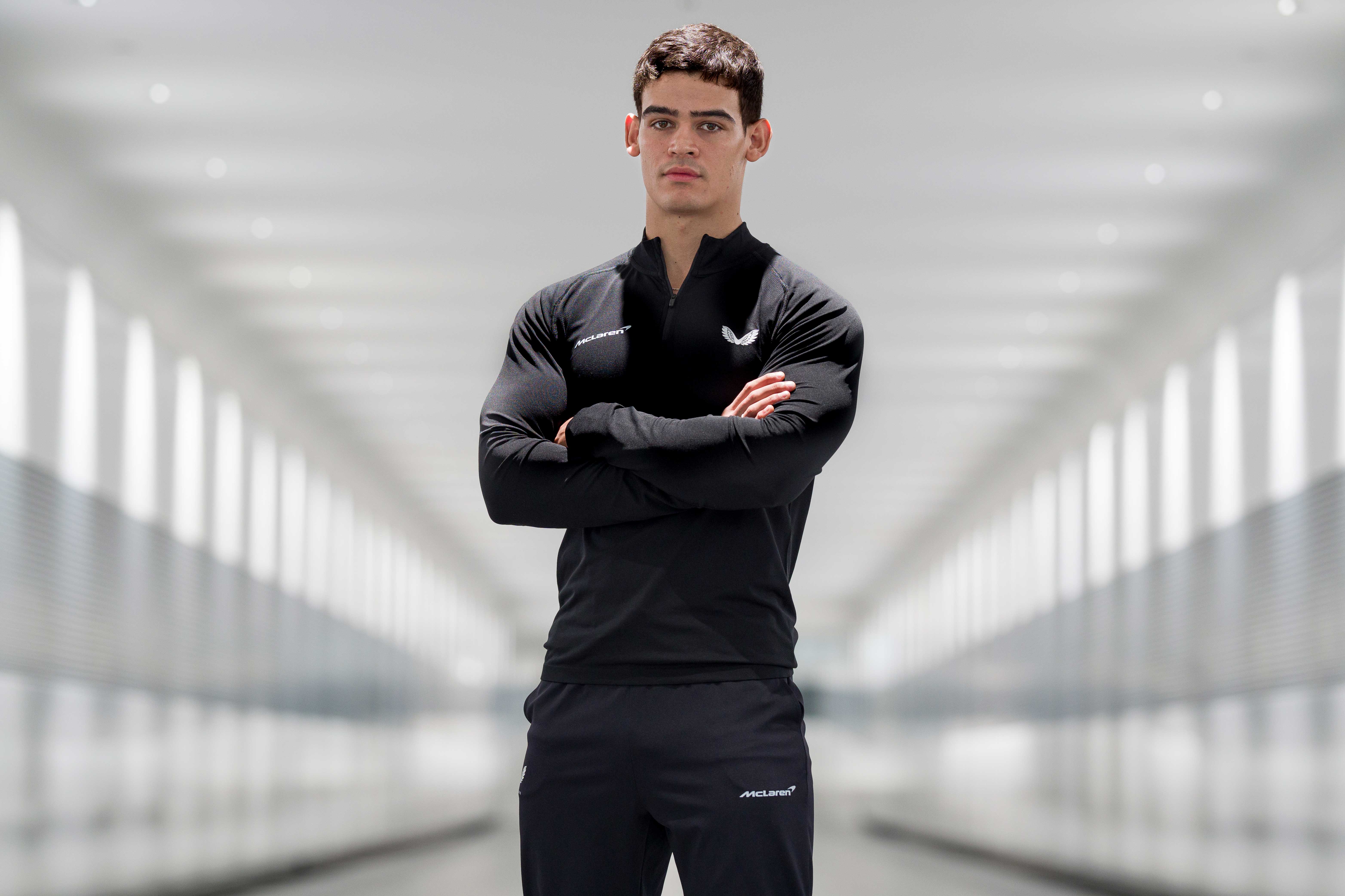 Male model wearing all black McLaren Castore clothing.