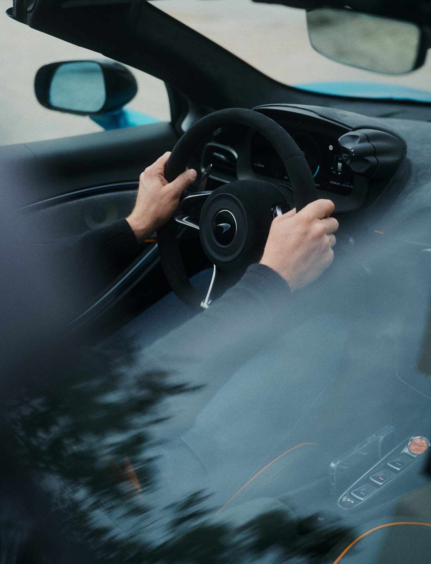 A McLaren customer holding the steering wheel of the McLaren Artura Spider.