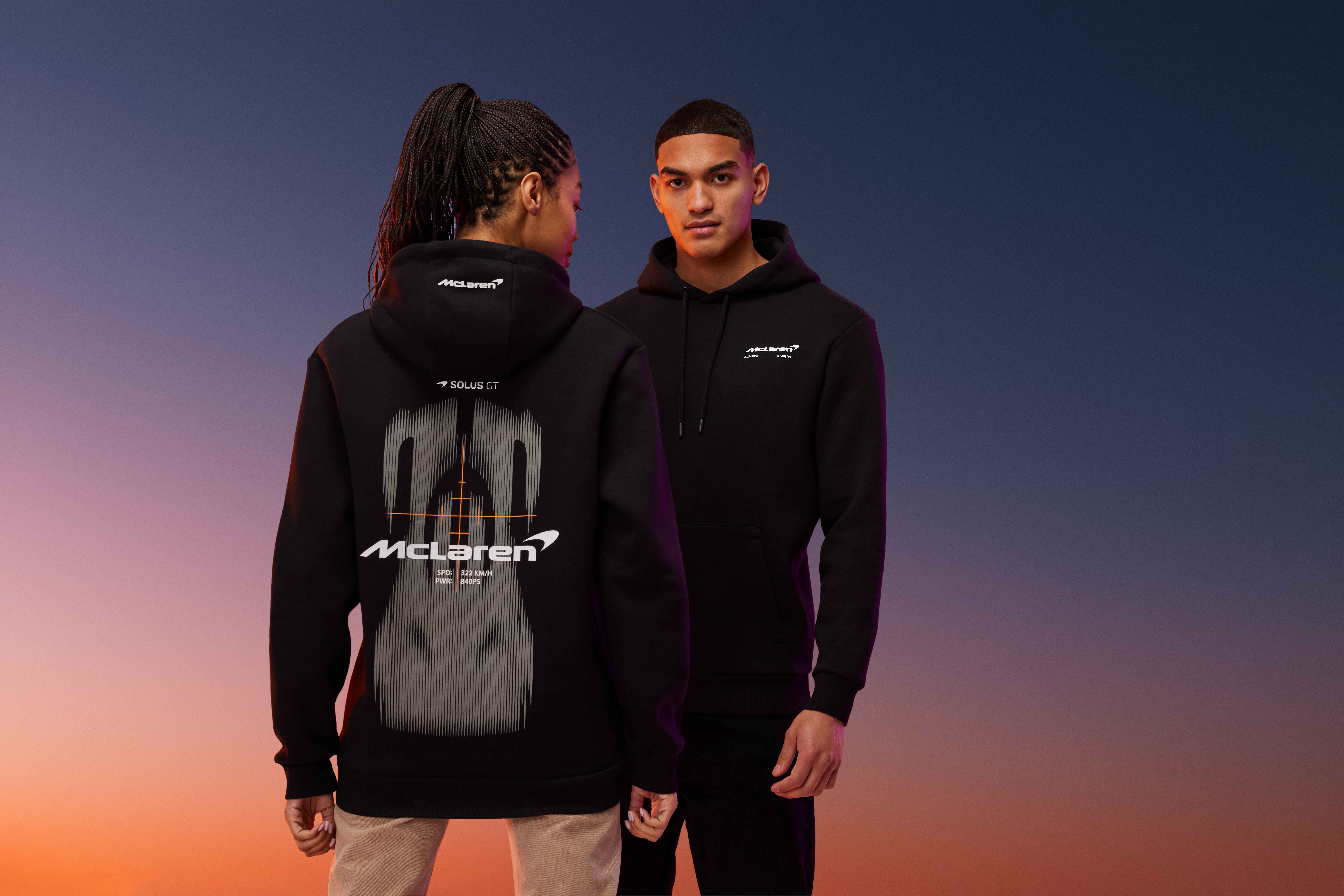 A male and female model wearing black McLaren Castore hoodies. 