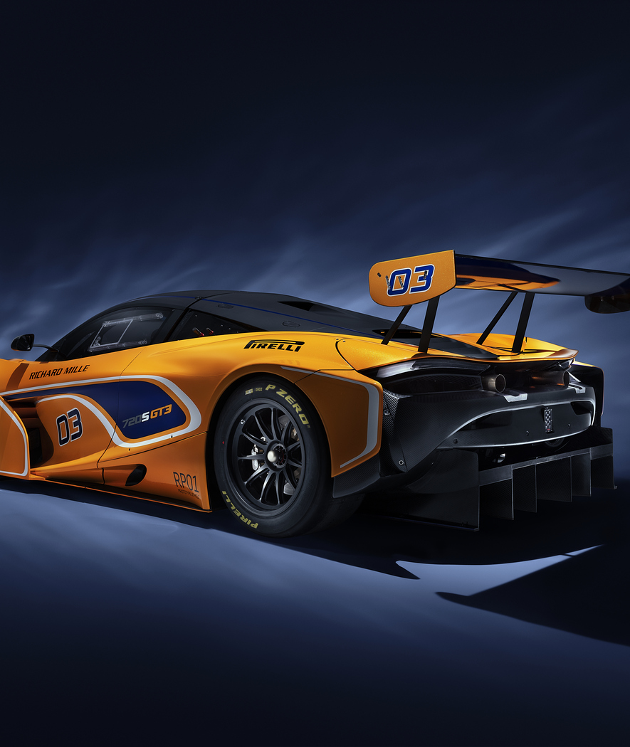 Rear side view of McLaren Racing 720S GT3 photographed on a dark studio background.