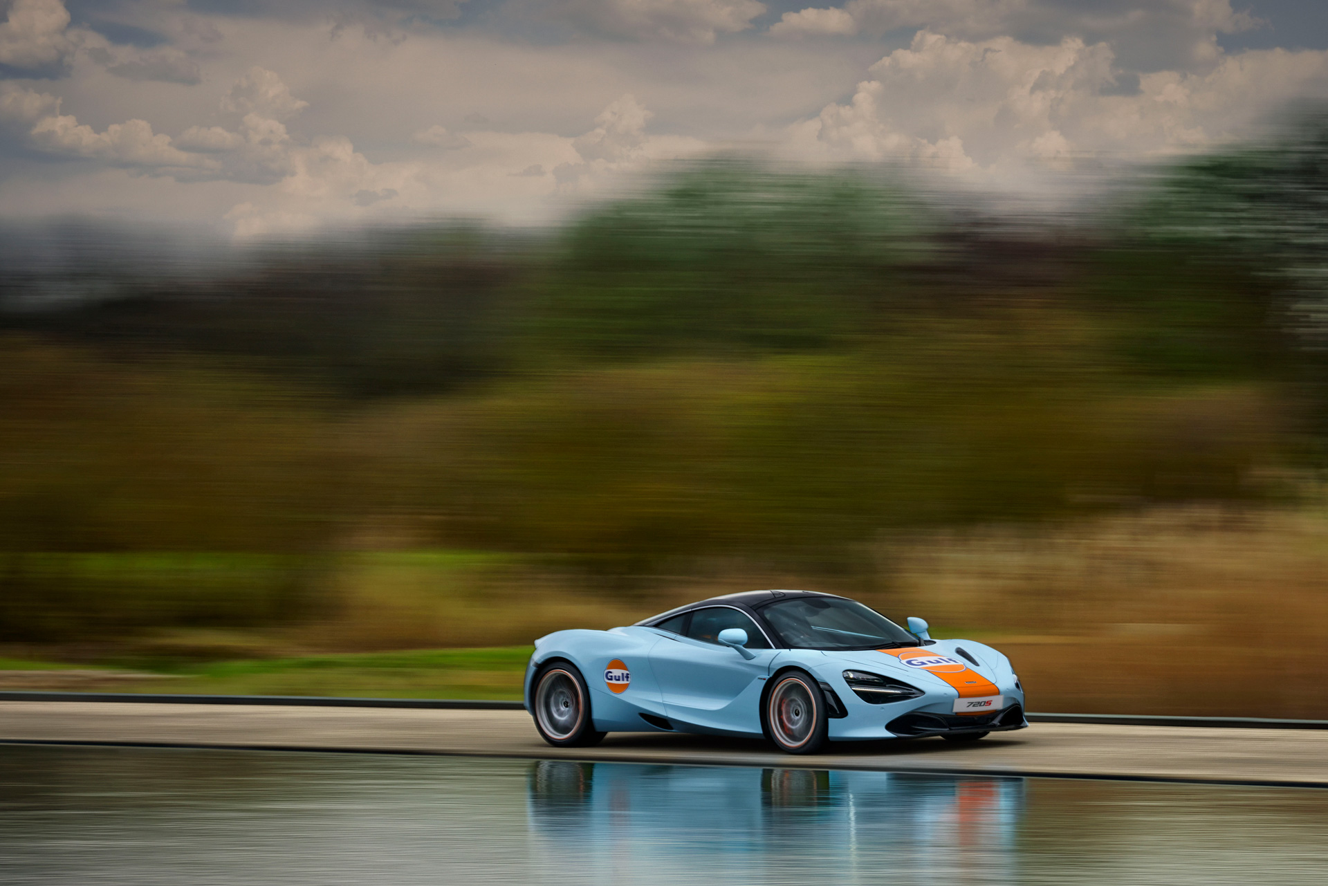 Gulf branded McLaren driving at speed.