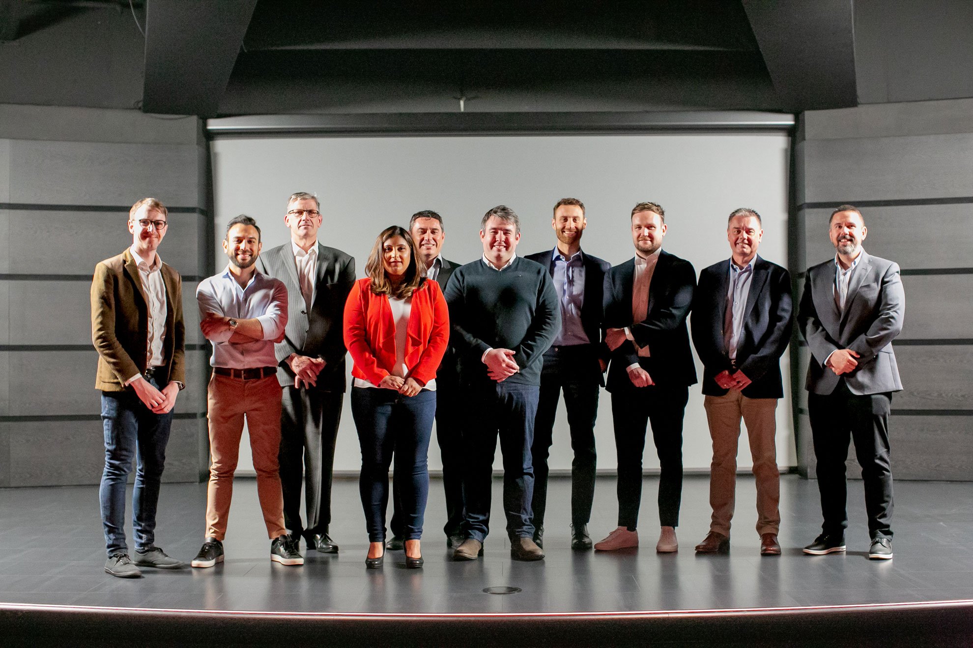 A diverse group of McLaren employees standing together for a team photo.