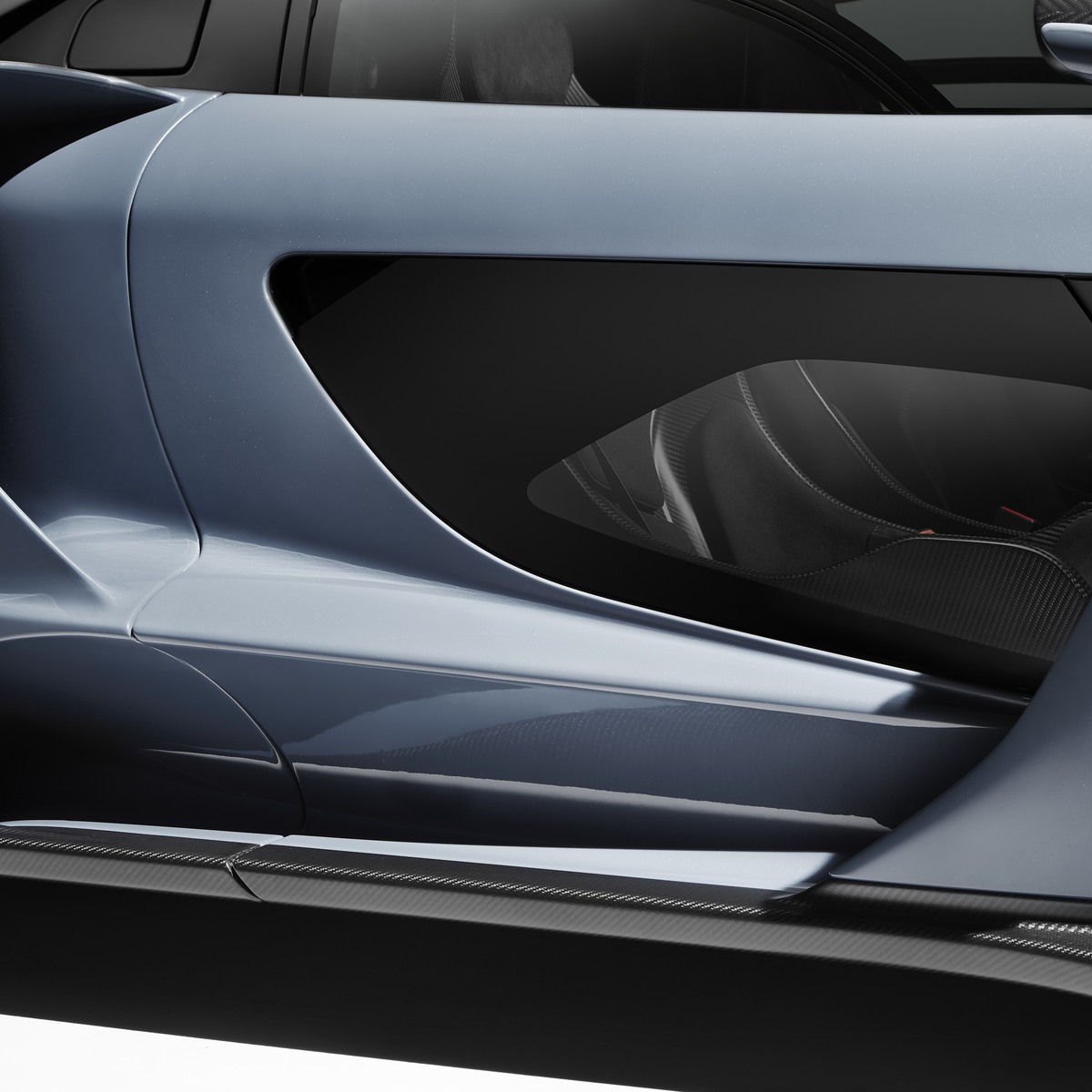 Close-up of the sculpted side profile and carbon fibre details of a grey McLaren 765LT.